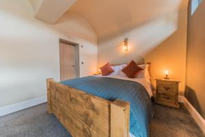 a bedroom with a large bed with a wooden frame at Hodbarrow House in Millom