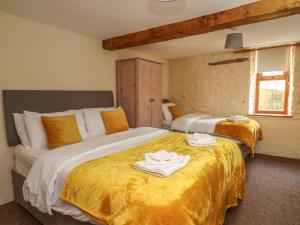 a bedroom with two beds with towels on them at Y Felin in Llanybydder