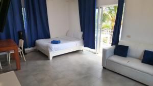 a room with a bed and a couch and a window at Punta Cana Sol Caribe Beach Pool in Punta Cana +82 photos