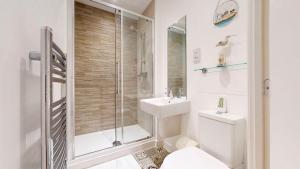 a bathroom with a shower and a toilet and a sink at Candy Dene, Top Floor Apartment in Swanscombe