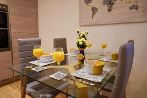 einen Esstisch mit Gläsern Orangensaft in der Unterkunft Candy Dene, Top Floor Apartment in Swanscombe