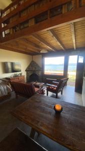 a living room with a table and a fireplace at Bosque Del Sur Cabañas in Ushuaia