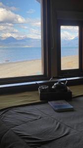 a bedroom with a view of the ocean from a window at Bosque Del Sur Cabañas in Ushuaia