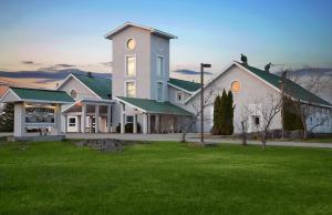 una grande casa bianca con un prato verde di Prospectors Inn a Kirkland Lake