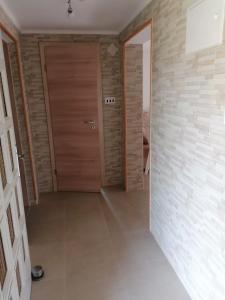 een hal met twee houten deuren en een tegelvloer bij Kuća za odmor ANA in Ljubač