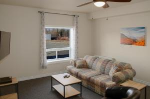 sala de estar con sofá y ventana en Prospectors Inn en Kirkland Lake