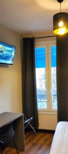 モントルイユにあるHÔTEL ROYAL MONTREUILの窓、デスク、窓が備わる客室です。