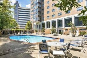 einen Pool mit Stühlen und einem Tisch sowie ein Gebäude in der Unterkunft Downtown ATL Condo Walk Score 78 w Free Parking LM1104 in Atlanta