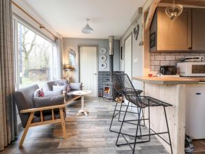 a kitchen and living room with a couch and chairs at Chalet Forte in Aberdyfi