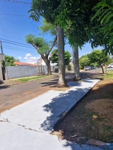 a sidewalk with trees on the side of a street at Casa Cataratas in Foz do Iguaçu +10 photos