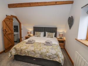 1 dormitorio con 1 cama grande y 2 mesitas de noche en The Stables en Bromsgrove
