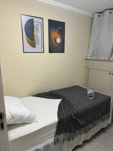 a bedroom with a bed with two pictures on the wall at Apto aconchegante cecapGuarulhos in Guarulhos