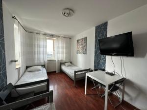 a small room with a desk and a tv at Pokoje Centrum/ rooms in Centre in Warsaw
