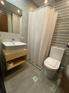 uma casa de banho com um lavatório, um WC e um chuveiro em Glaros Hotel em Piraeus