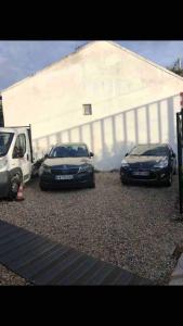 twee auto's geparkeerd op een parkeerplaats naast een gebouw bij Logement appartement bourget in Le Bourget