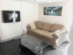 a living room with a couch and a glass table at Logement appartement bourget in Le Bourget