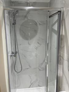 a shower with a glass door in a bathroom at 87 classic comfort in harrow in Hatch End
