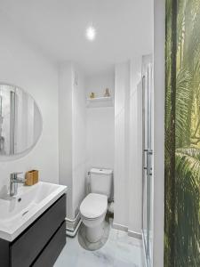 een witte badkamer met een toilet en een wastafel bij L'Harmonie de Livry in Livry-Gargan