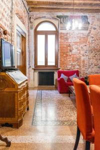 a living room with a tv and a brick wall at Spazio Seicentesco in Verona