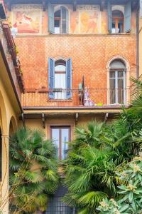 ceglany budynek z niebieskimi oknami i balkonem w obiekcie Spazio Seicentesco w Weronie