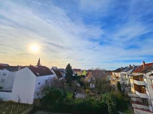 - une vue sur la ville et le soleil dans le ciel dans l'établissement Apartmenthaus - Ludwigshafen, à Ludwigshafen