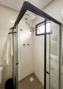 a shower with a glass door in a bathroom at Flat a beira mar da Praia de Guaratuba Bertioga SP in Praia Guaratuba
