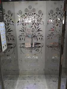 a bathroom with a shower with a tile wall at Pachmarhi Shri Krishna Hotel in Pachmarhī