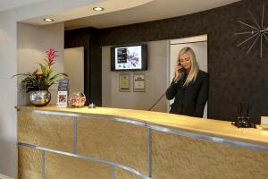a woman talking on a cell phone at a reception counter at The Dean Court in York