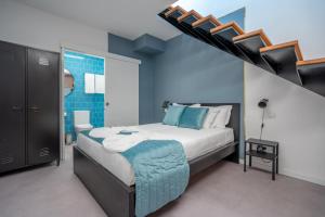 豐沙爾的住宿－Social Lodge - Piornais，一间卧室设有床铺,楼梯拥有蓝色的墙壁