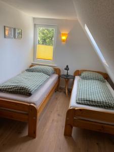 two beds in a room with a window at Sofort am Strand! in Kiel
