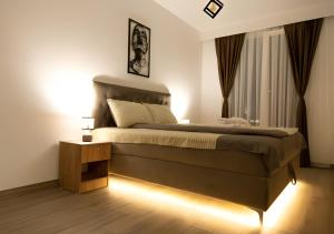 a bedroom with a large bed with lights on it at Horizon Grey Apartment & Spa in Skopje