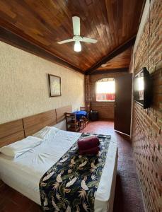 a bedroom with a bed and a ceiling fan at Pousada Cantim de BH in Venda Nova