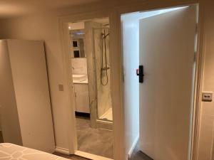 a bathroom with a shower and a white door at 87 classic comfort in harrow in Hatch End