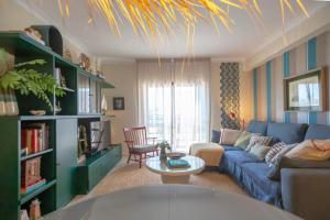 ein Wohnzimmer mit einem blauen Sofa und einem Tisch in der Unterkunft Apartamento acolhedor em Lagos in Lagos