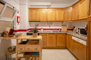 eine Küche mit Holzschränken und einer Spüle in der Unterkunft Apartamento acolhedor em Lagos in Lagos + 11 Fotos