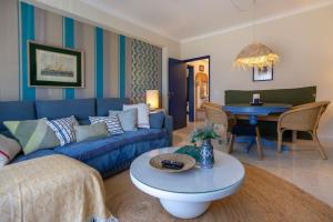 ein Wohnzimmer mit einem blauen Sofa und einem Tisch in der Unterkunft Apartamento acolhedor em Lagos in Lagos