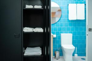 a bathroom with a toilet and blue tiles at Social Lodge - Piornais in Funchal +33 photos