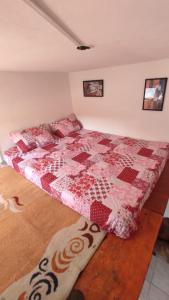 1 dormitorio con 1 cama con edredón rojo en Meu Cantinho Aconchegante Lençóis, en Lençóis