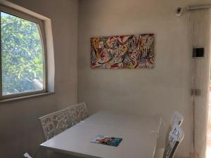 una mesa y sillas con una pintura en la pared en TRILOCALE 2 SUL MARE, en Peschici