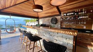 a bar with chairs and a stone wall at HOTEL VILLE LA PLAGE & BEACH CLUB in Búzios