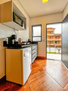 a kitchen with a sink and a refrigerator at Incrivel flat a beira mar na Praia de Guaratuba SP in Praia Guaratuba