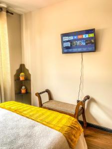 een kamer met een bed en een tv aan de muur bij Acogedor departamento céntrico in Cochabamba