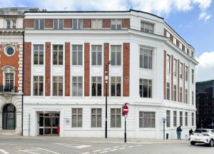 a large white building on the corner of a street at Toothbrush Apartments - Town Centre - Century House in Ipswich