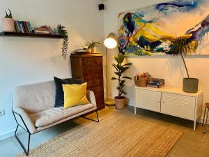 a living room with a chair and a painting at Maison De La Muzelle, Venosc - Les Deux Alpes in Vénosc