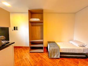 a small room with a bed and a closet at Otimo flat a beira mar na Praia de Guaratuba SP in Bertioga