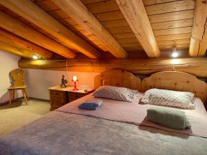 ein großes Bett in einem Zimmer mit Holzdecken in der Unterkunft Chalet near St.Moritz in Madulain