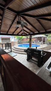 a large grill on a patio with a pool at Cabaña con piscina en Minca in Minca