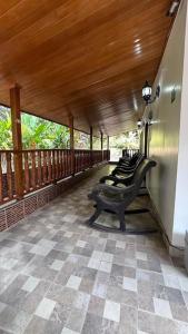 a porch with a row of benches on a deck at Cabaña con piscina en Minca in Minca