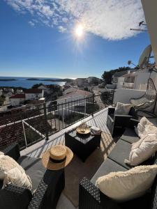 Un balcón con sofás y mesas y vistas al océano. en Apartments Tino, en Hvar