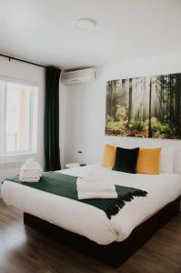 Suite 205 - Destination Mont-Orford في ماجوج-اورفورد: غرفة نوم بسرير كبير عليها مناشف